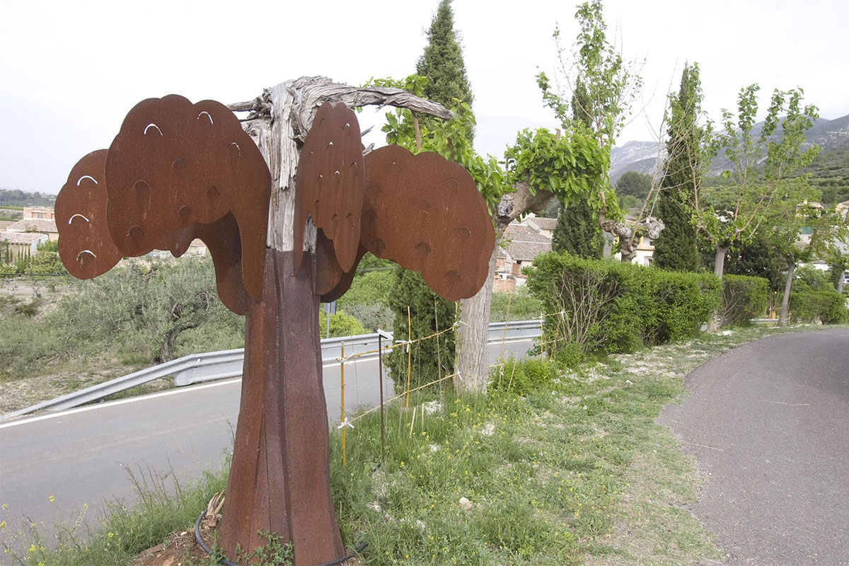 Foto realizada por PERALES IBORRA.  Escultura de 2m de altura en Carricola, hecha con chapa de acero corten, que representa un árbol con raíces de un árbol viejo en su copa.